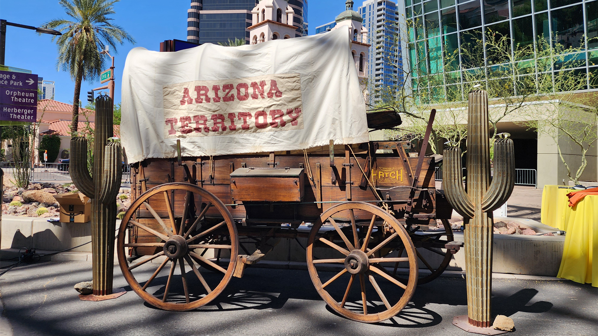 A covered wagon labeled "Arizona Territory" rests next to a cactus