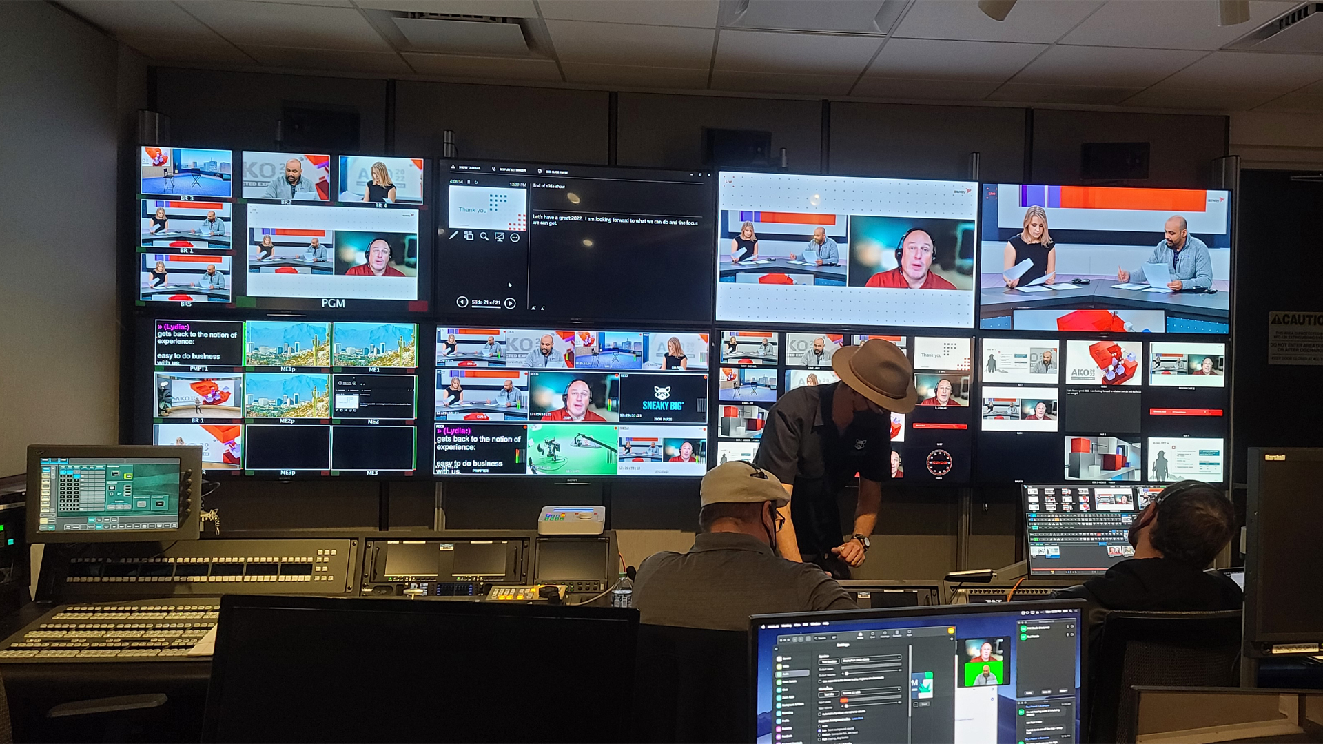 Multiple monitors and crew members manage and event behind the scenes