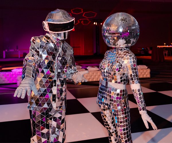 Disco Dancers Two figures wearing futuristic suits covered in disco-ball mirrors