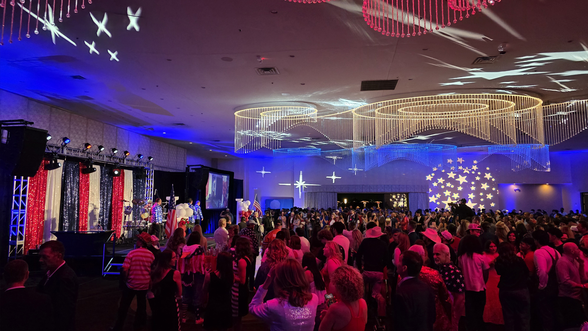 Party-goers gather at a red, white, and blue-themed event